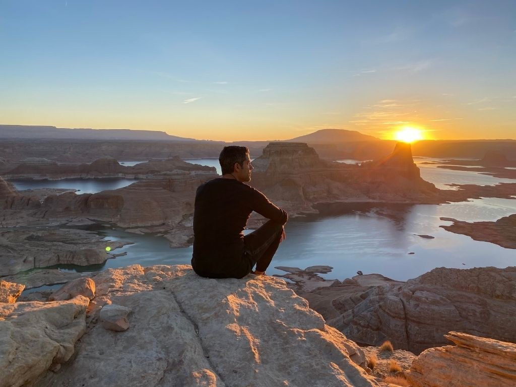 Hamada reflecting above a river landscape at sunset